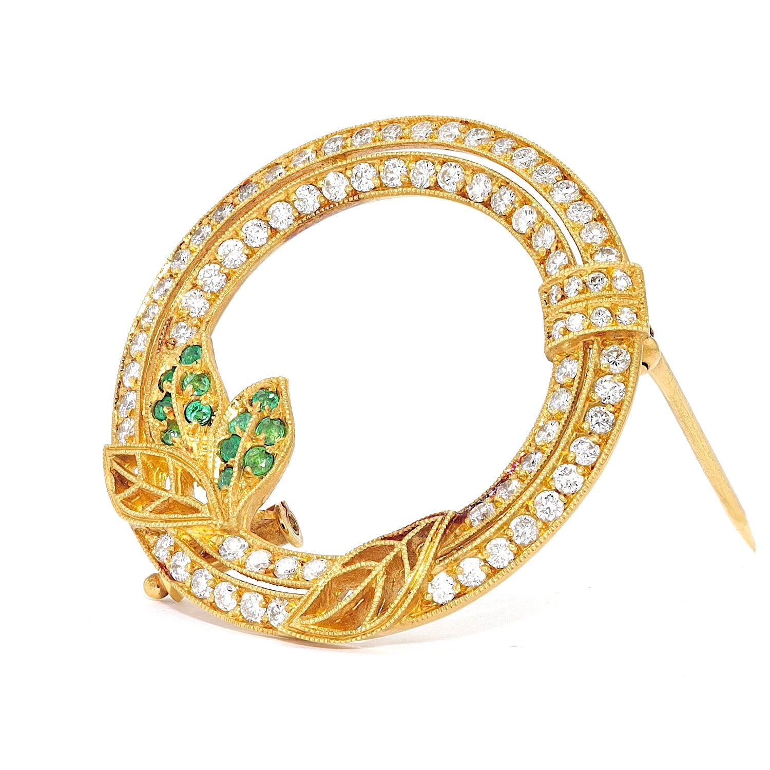 Brosche aus 750er Gelbgold mit Brillanten und Smaragden, stehend inks gedreht