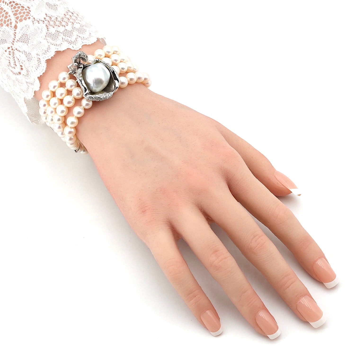 Armband mit 4 Reihen Südsee- und Akoya-Zuchtperlen und einem Schloss und Stegen aus 750er Weißgold mit Brillanten, an der Hand