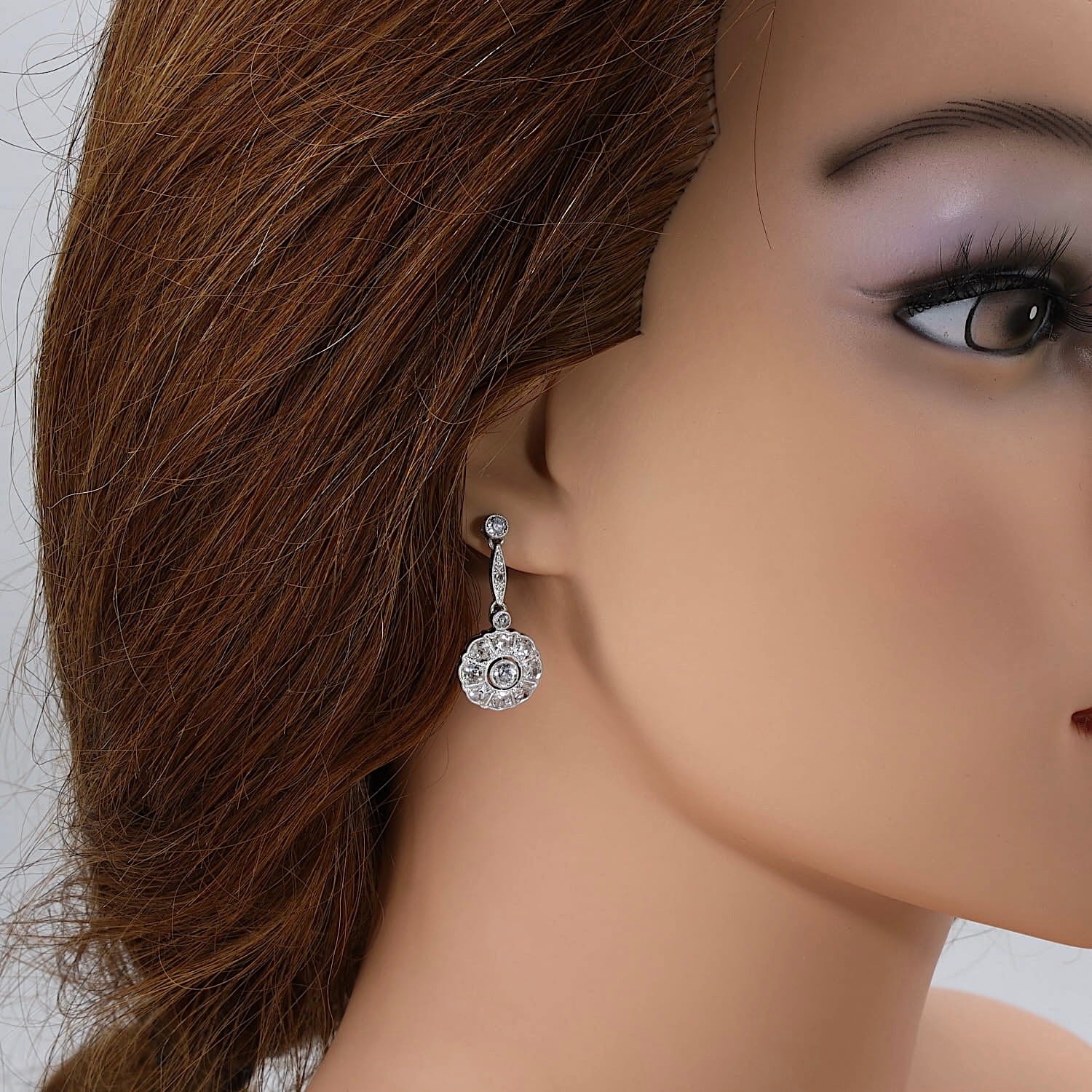 Art Deco Ohrringe in 585/750er Weißgold und Platin mit insgesamt ca. 1,8 ct Diamanten, am Ohr einer Puppe