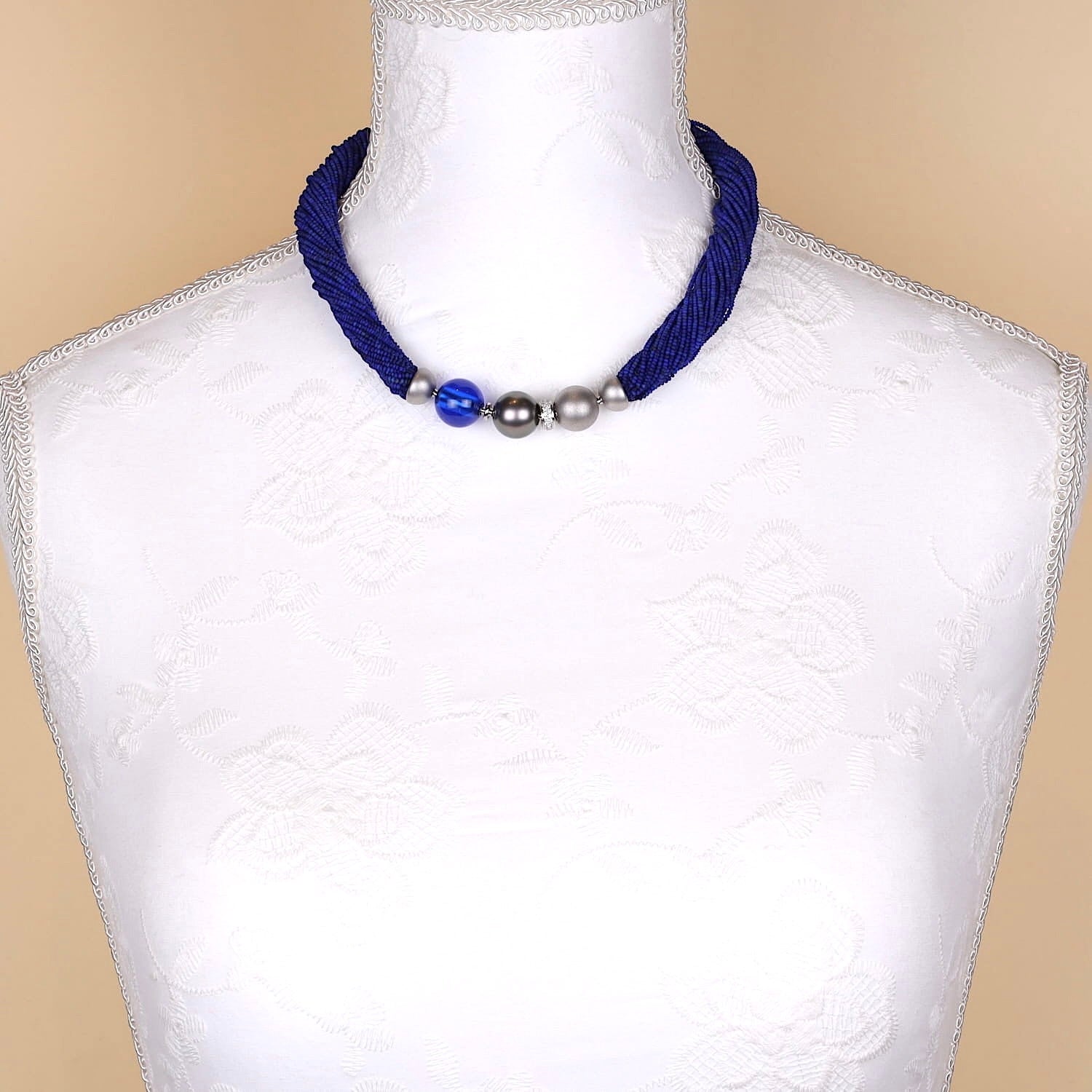 Jörg Heinz Collier mit 39 Strängen aus Lapis lazuli, einem 750er Weißgoldschloss mit Brillanten, einer Tahiti-Zuchtperle und einer blauen Kugel aus synthetischem Spinell, an einer Büste