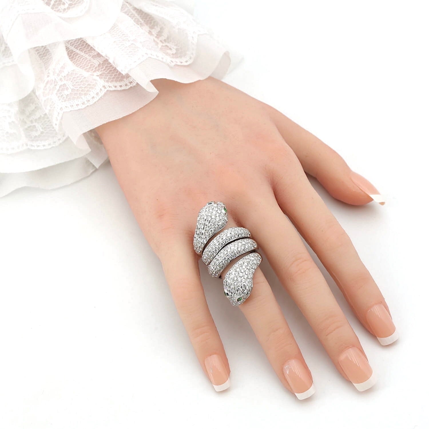 Exklusiver Schlangenring in 750er Weißgold mit insgesamt ca. 7,2 ct Brillanten und 4 Tsavorithe, an einer künstlichen Hand