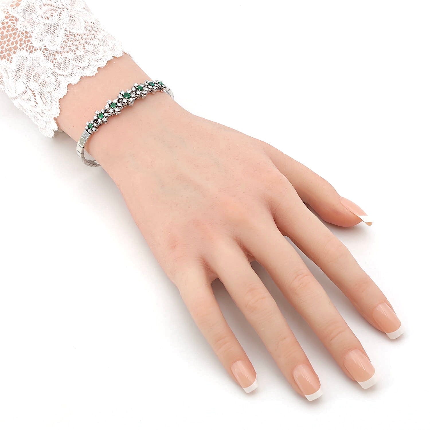 Armband in 750er Weißgold mit Diamanten, Brillanten und Smaragden, an einem künstlichen Arm