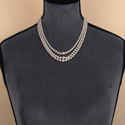 Wien - Art Deco Zuchtperlencollier mit drei Strängen im Verlauf, Schloss 585er Gelbgold mit einem Smaragd, an einer dunklen Büste Schloss hinten