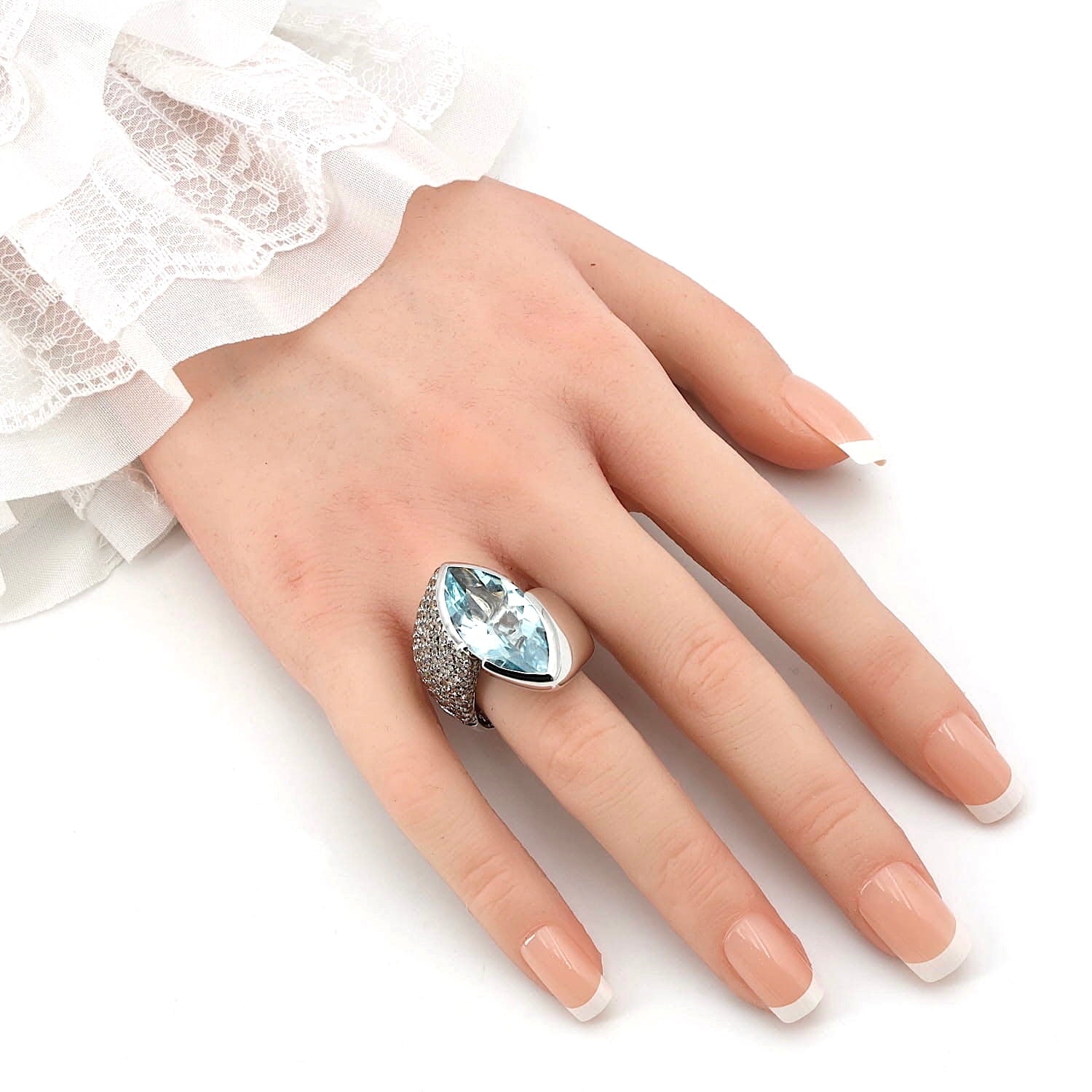 Wempe Ring in 750er Weißgold mit einem Aquamarin ca. 10,8 ct  und ca. 2,8 ct champagnerfarbene Brillanten, an einer künstlichen Hand