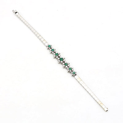 Armband in 750er Weißgold mit Diamanten, Brillanten und Smaragden, längs liegend